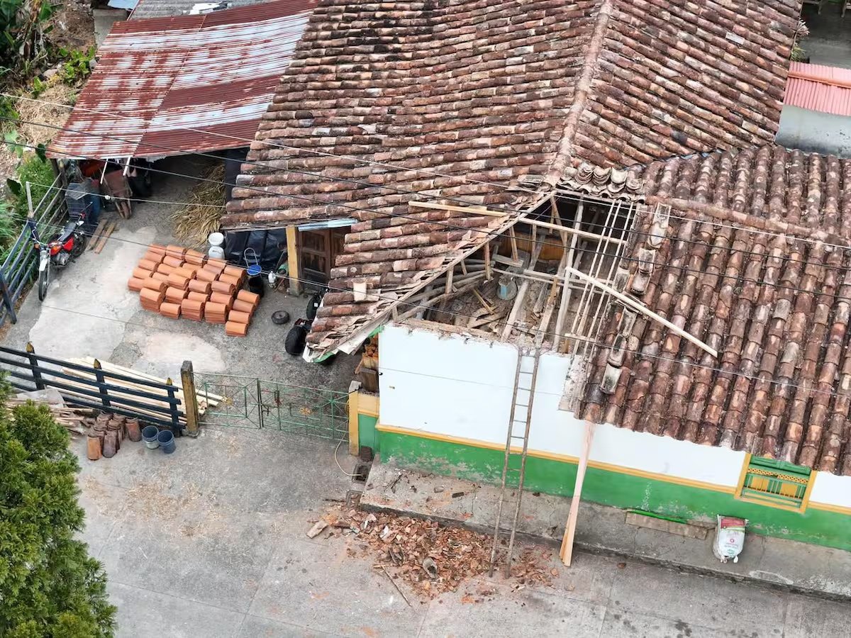 Vista de una vivienda con parte de la cubierta de tejas abierta tras el sismo en Antioquia.